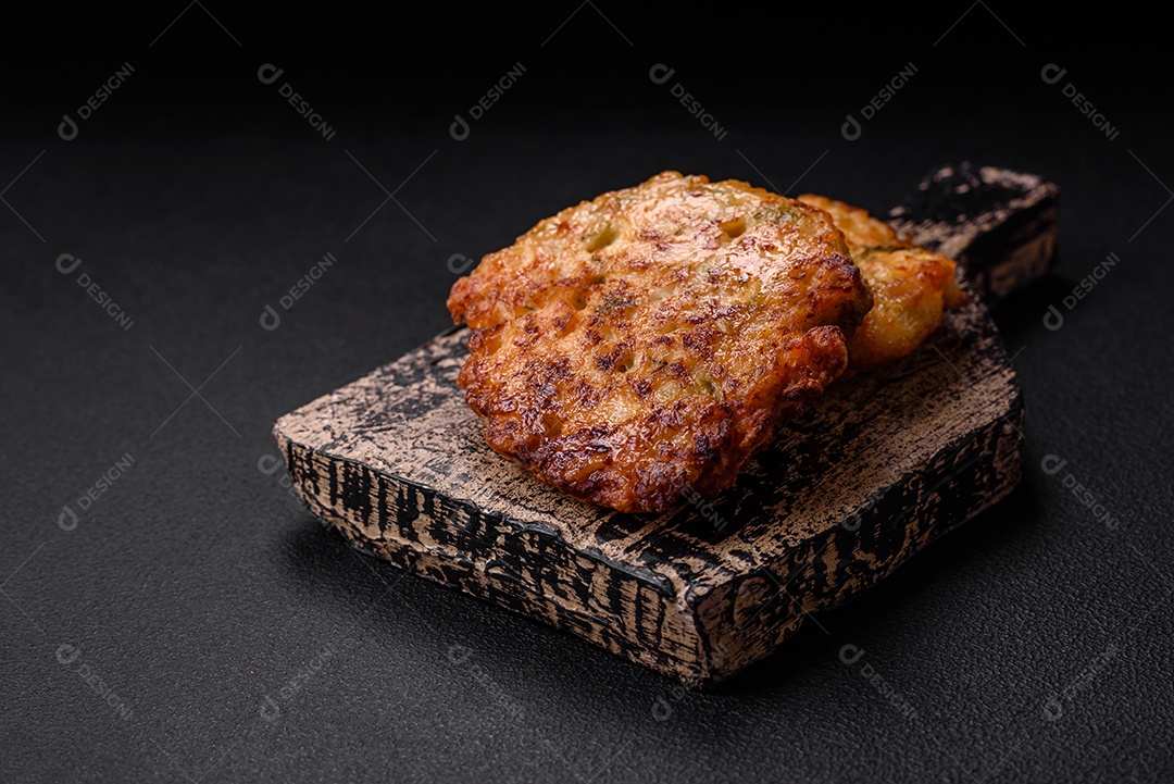 Deliciosos legumes grelhados, abobrinha, berinjela, pimentão e cogumelos com sal, especiarias e ervas sobre um fundo escuro de concreto