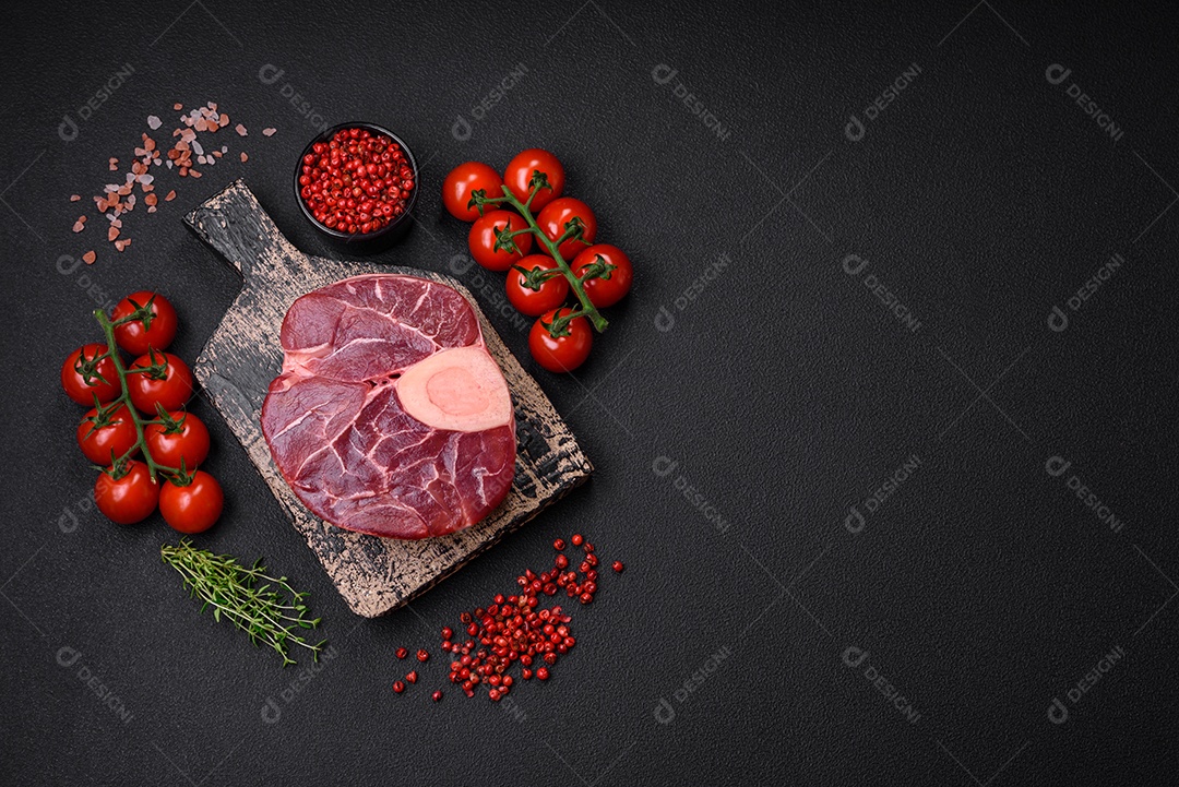 Bife cru fresco com osso ou ossobuco com sal, especiarias e ervas em fundo escuro de concreto