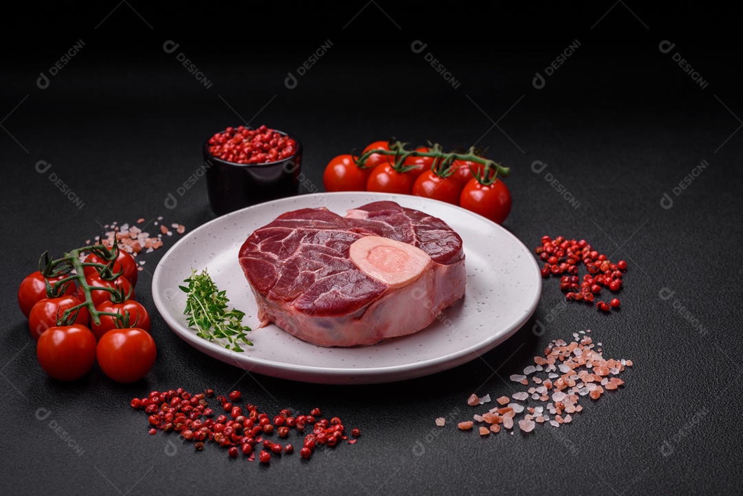 Bife cru fresco com osso ou ossobuco com sal, especiarias e ervas em fundo escuro de concreto