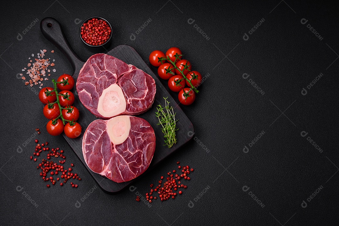 Bife cru fresco com osso ou ossobuco com sal, especiarias e ervas em fundo escuro de concreto