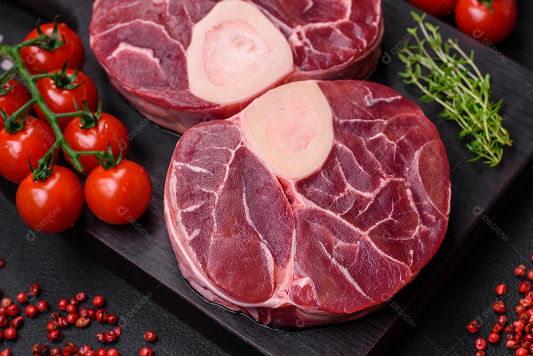 Bife cru fresco com osso ou ossobuco com sal, especiarias e ervas em fundo escuro de concreto