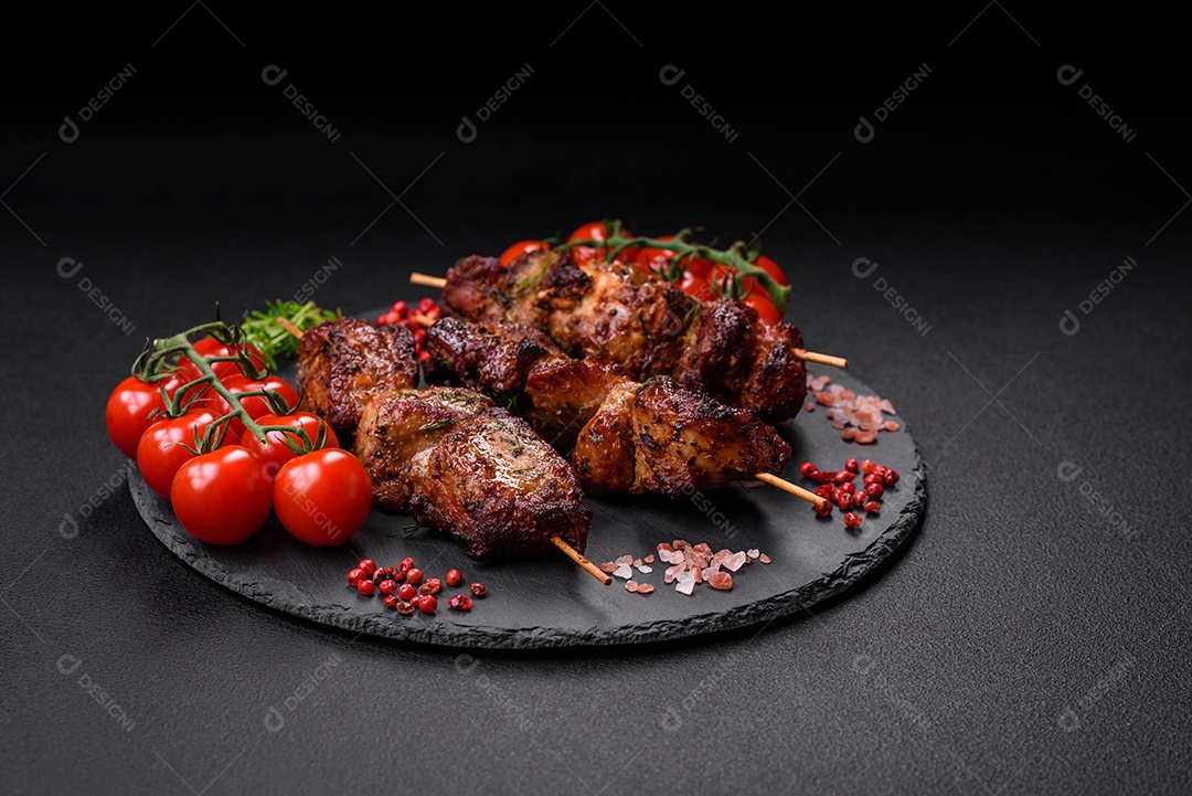 Deliciosos espetos de frango, peru ou porco grelhados com sal, especiarias e ervas no fogo sobre um fundo escuro de concreto