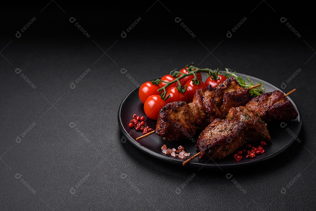 Deliciosos espetos de frango, peru ou porco grelhados com sal, especiarias e ervas no fogo sobre um fundo escuro de concreto