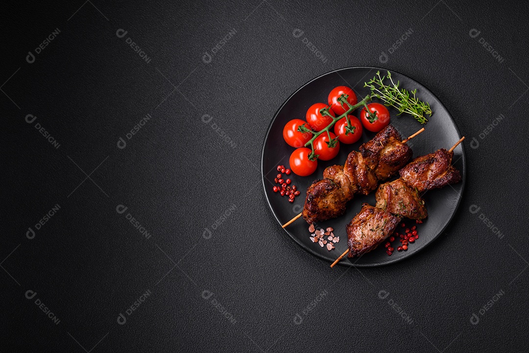 Deliciosos espetos de frango, peru ou porco grelhados com sal, especiarias e ervas no fogo sobre um fundo escuro de concreto