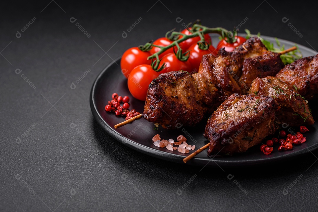 Deliciosos espetos de frango, peru ou porco grelhados com sal, especiarias e ervas no fogo sobre um fundo escuro de concreto