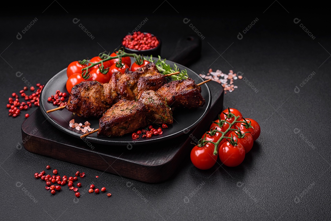 Deliciosos espetos de frango, peru ou porco grelhados com sal, especiarias e ervas no fogo sobre um fundo escuro de concreto