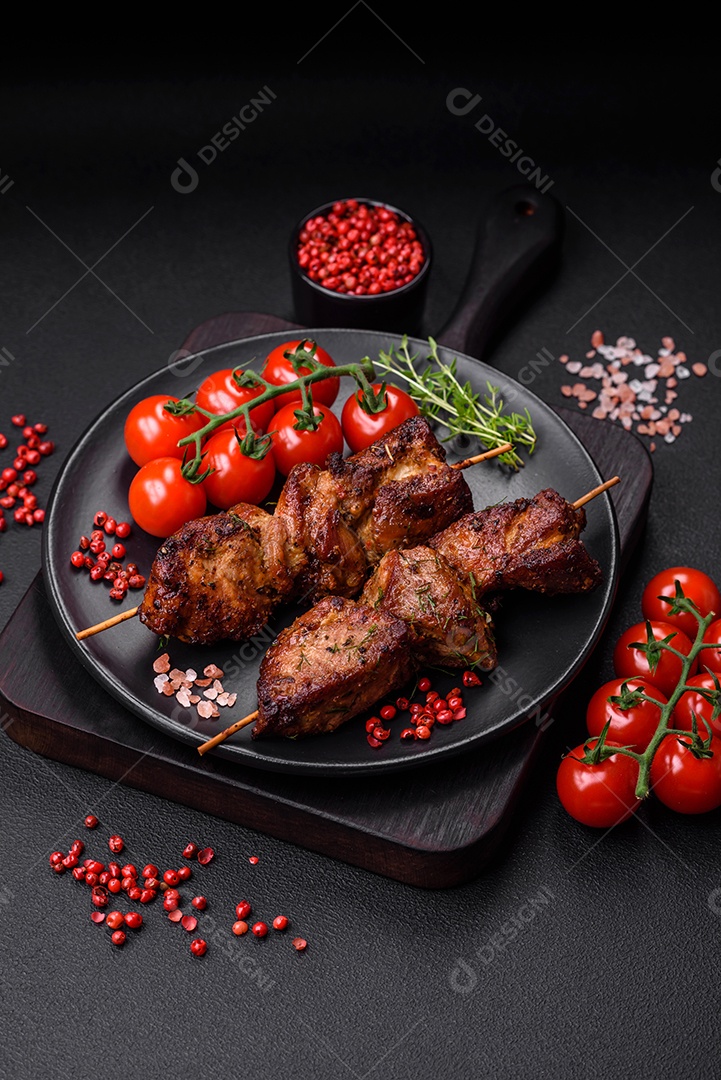 Deliciosos espetos de frango, peru ou porco grelhados com sal, especiarias e ervas no fogo sobre um fundo escuro de concreto