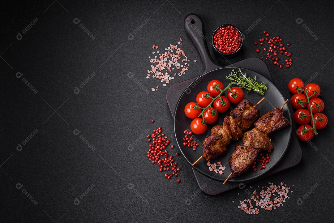 Deliciosos espetos de frango, peru ou porco grelhados com sal, especiarias e ervas no fogo sobre um fundo escuro de concreto
