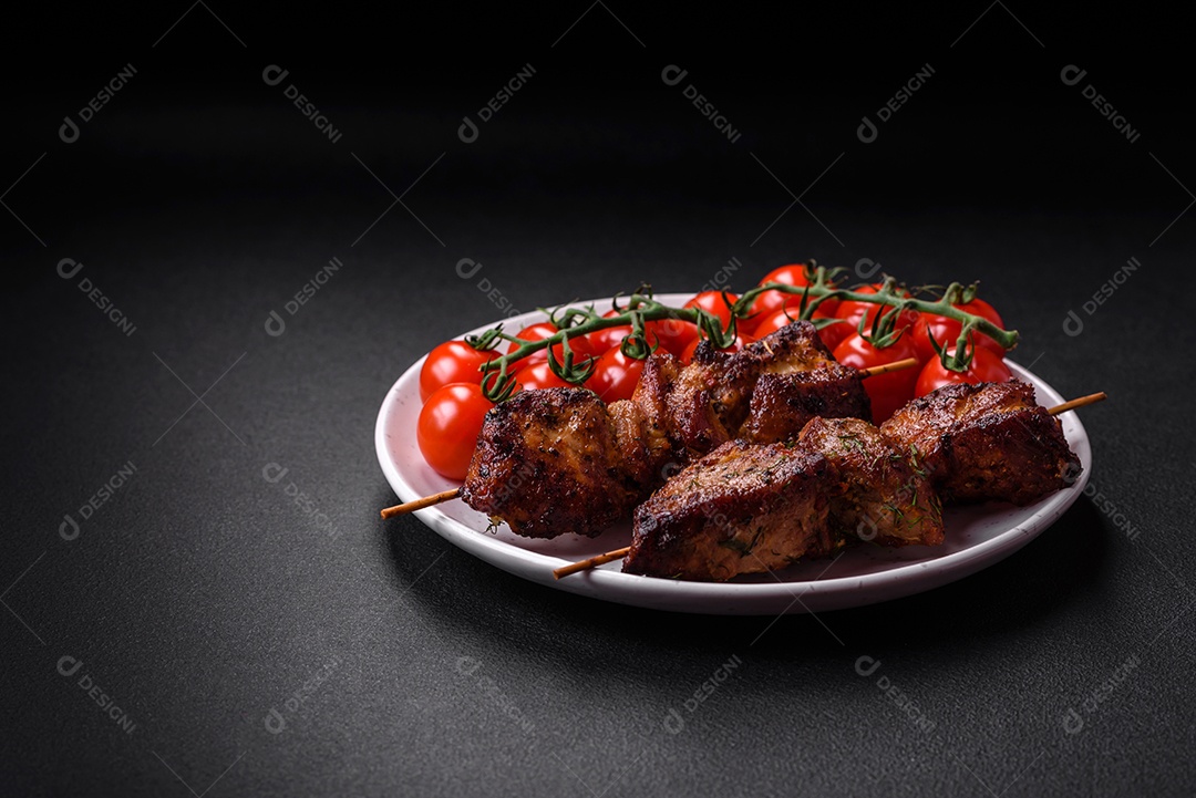 Deliciosos espetos de frango, peru ou porco grelhados com sal, especiarias e ervas no fogo sobre um fundo escuro de concreto
