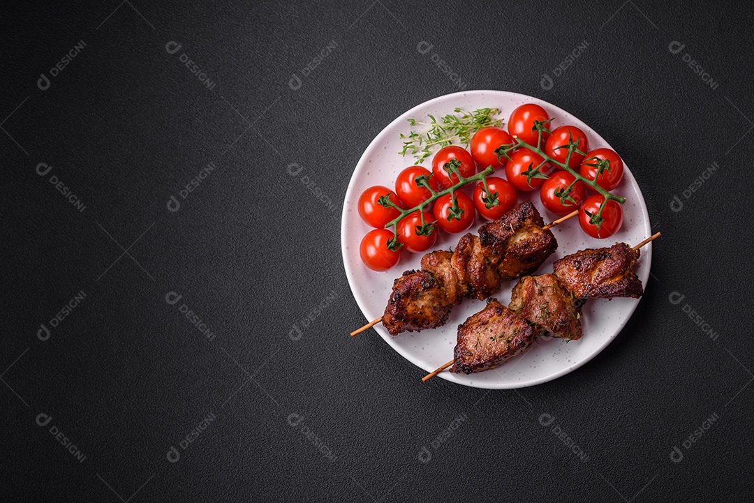 Deliciosos espetos de frango, peru ou porco grelhados com sal, especiarias e ervas no fogo sobre um fundo escuro de concreto