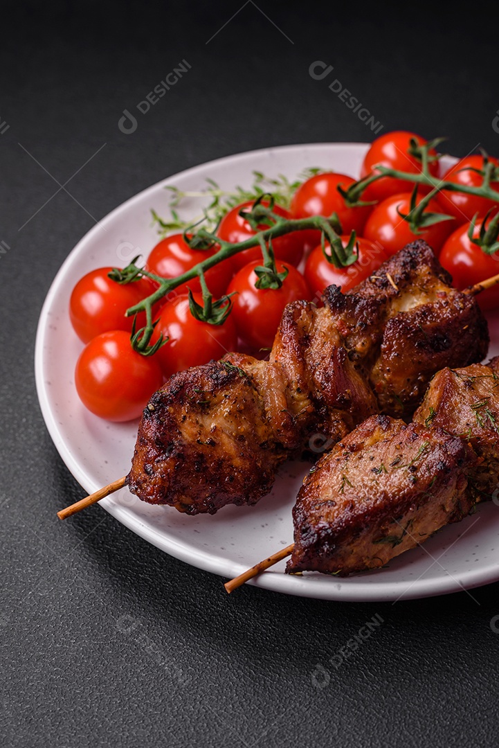 Deliciosos espetos de frango, peru ou porco grelhados com sal, especiarias e ervas no fogo sobre um fundo escuro de concreto