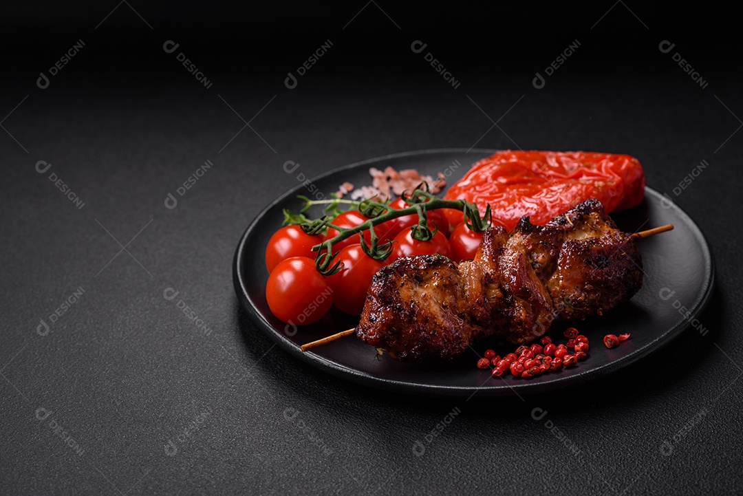 Deliciosos espetos de frango, peru ou porco grelhados com sal, especiarias e ervas no fogo sobre um fundo escuro de concreto