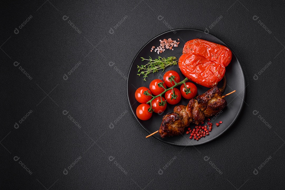 Deliciosos espetos de frango, peru ou porco grelhados com sal, especiarias e ervas no fogo sobre um fundo escuro de concreto
