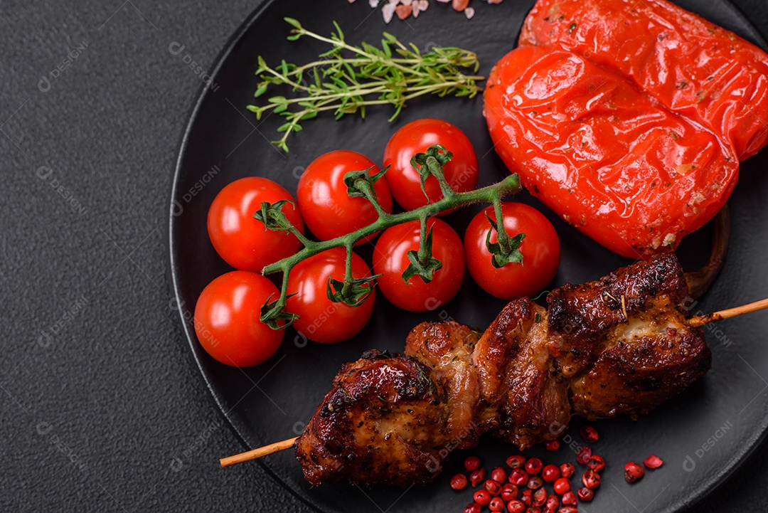 Deliciosos espetos de frango, peru ou porco grelhados com sal, especiarias e ervas no fogo sobre um fundo escuro de concreto