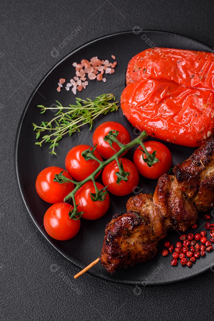 Deliciosos espetos de frango, peru ou porco grelhados com sal, especiarias e ervas no fogo sobre um fundo escuro de concreto