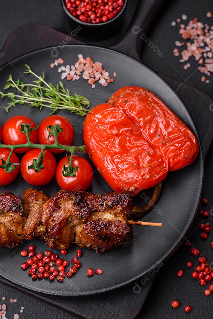 Deliciosos espetos de frango, peru ou porco grelhados com sal, especiarias e ervas no fogo sobre um fundo escuro de concreto