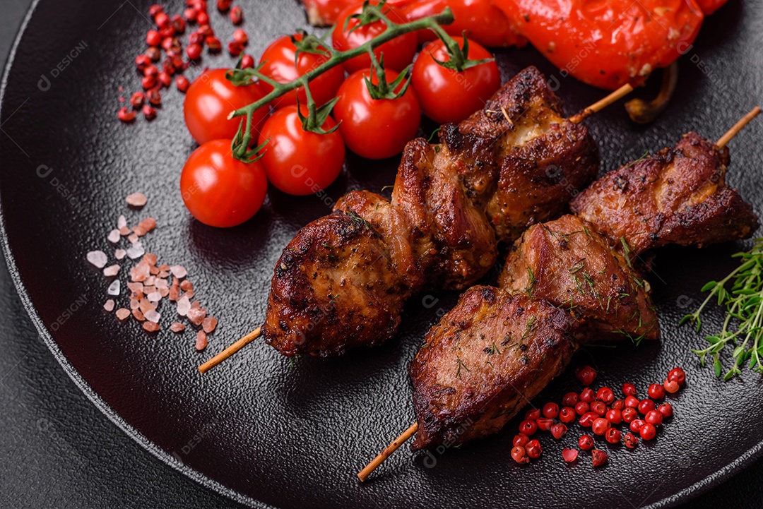 Deliciosos espetos de frango, peru ou porco grelhados com sal, especiarias e ervas no fogo sobre um fundo escuro de concreto