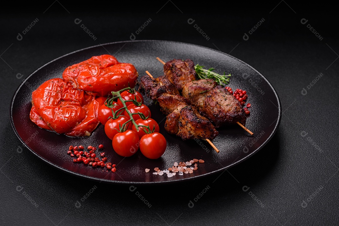 Deliciosos espetos de frango, peru ou porco grelhados com sal, especiarias e ervas no fogo sobre um fundo escuro de concreto