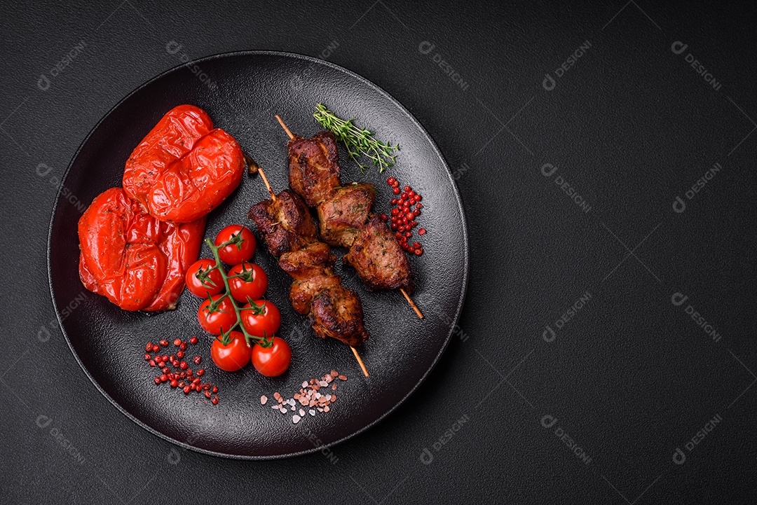 Deliciosos espetos de frango, peru ou porco grelhados com sal, especiarias e ervas no fogo sobre um fundo escuro de concreto
