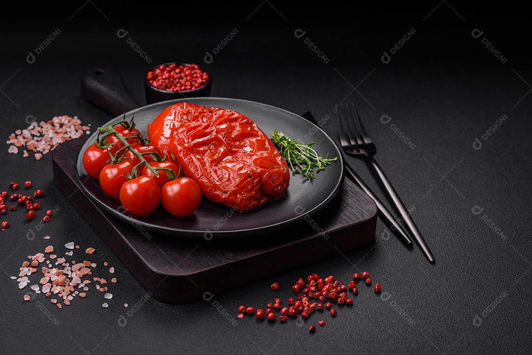 Deliciosos pimentões grelhados com especiarias e ervas em um fundo escuro de concreto