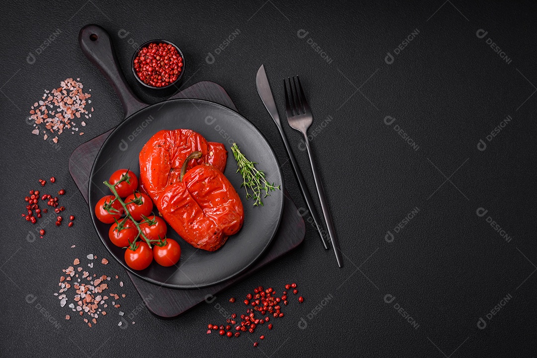 Deliciosos pimentões grelhados com especiarias e ervas em um fundo escuro de concreto