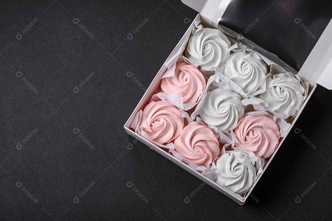 Delicioso marshmallow doce multicolorido em um fundo escuro de concreto. Doces saudáveis ​​para a mesa de jantar