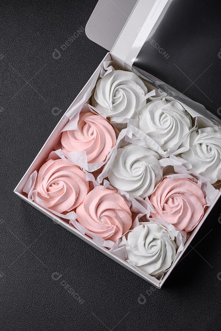 Delicioso marshmallow doce multicolorido em um fundo escuro de concreto. Doces saudáveis ​​para a mesa de jantar