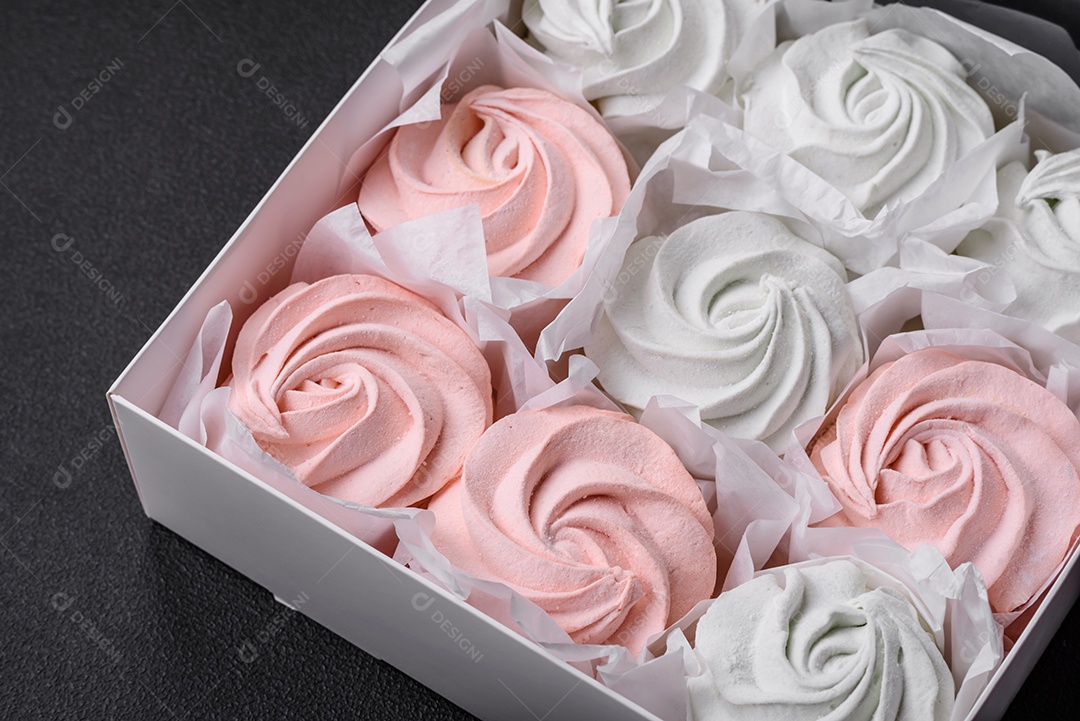 Delicioso marshmallow doce multicolorido em um fundo escuro de concreto. Doces saudáveis ​​para a mesa de jantar