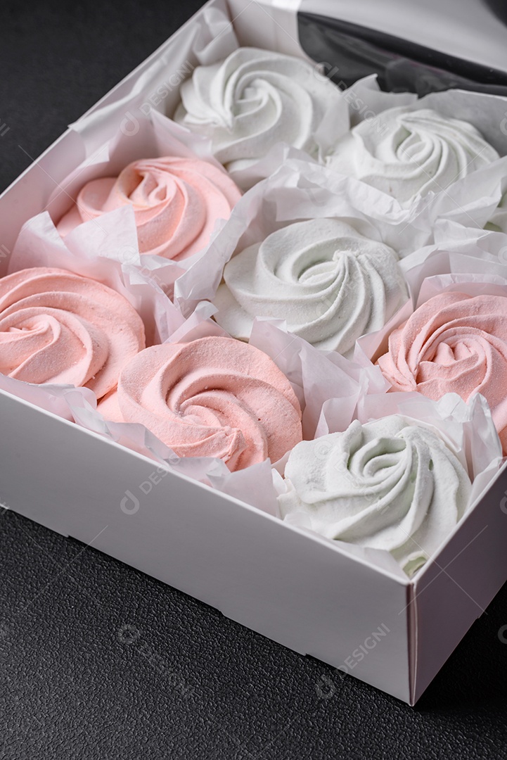 Delicioso marshmallow doce multicolorido em um fundo escuro de concreto. Doces saudáveis ​​para a mesa de jantar