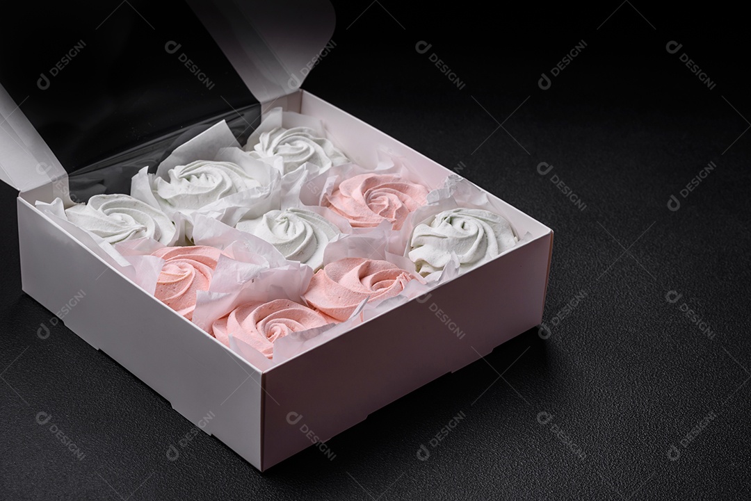 Delicioso marshmallow doce multicolorido em um fundo escuro de concreto. Doces saudáveis ​​para a mesa de jantar