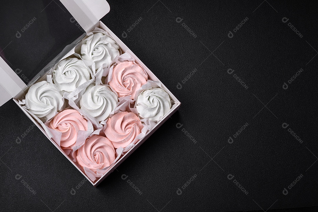 Delicioso marshmallow doce multicolorido em um fundo escuro de concreto. Doces saudáveis ​​para a mesa de jantar