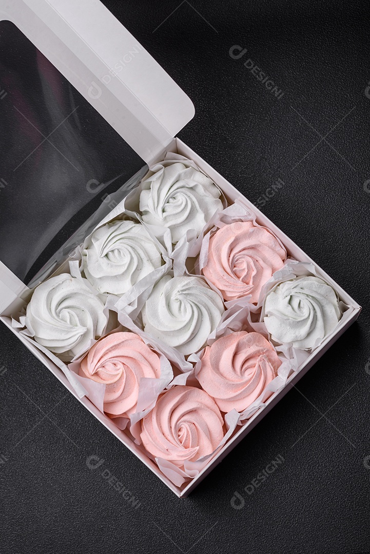 Delicioso marshmallow doce multicolorido em um fundo escuro de concreto. Doces saudáveis ​​para a mesa de jantar