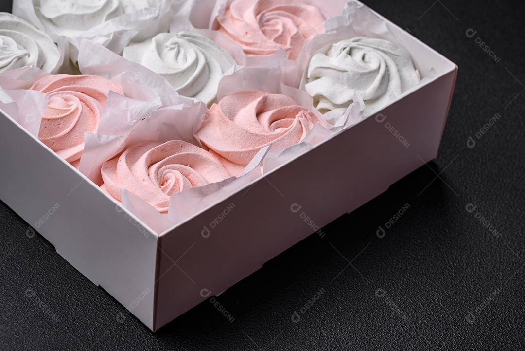 Delicioso marshmallow doce multicolorido em um fundo escuro de concreto. Doces saudáveis ​​para a mesa de jantar