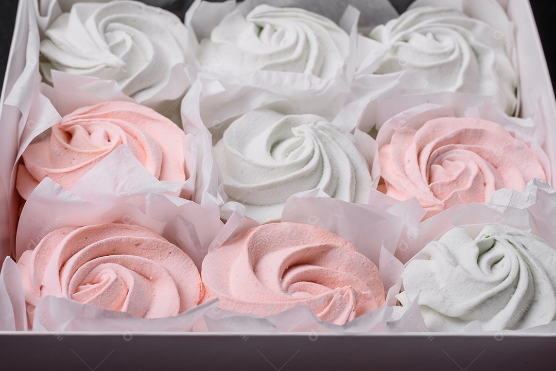 Delicioso marshmallow doce multicolorido em um fundo escuro de concreto. Doces saudáveis ​​para a mesa de jantar