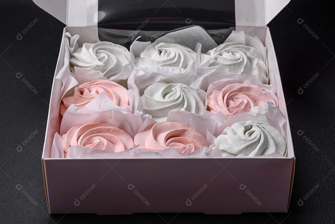 Delicioso marshmallow doce multicolorido em um fundo escuro de concreto. Doces saudáveis ​​para a mesa de jantar