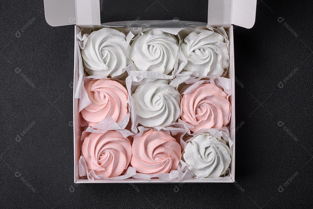 Delicioso marshmallow doce multicolorido em um fundo escuro de concreto. Doces saudáveis ​​para a mesa de jantar