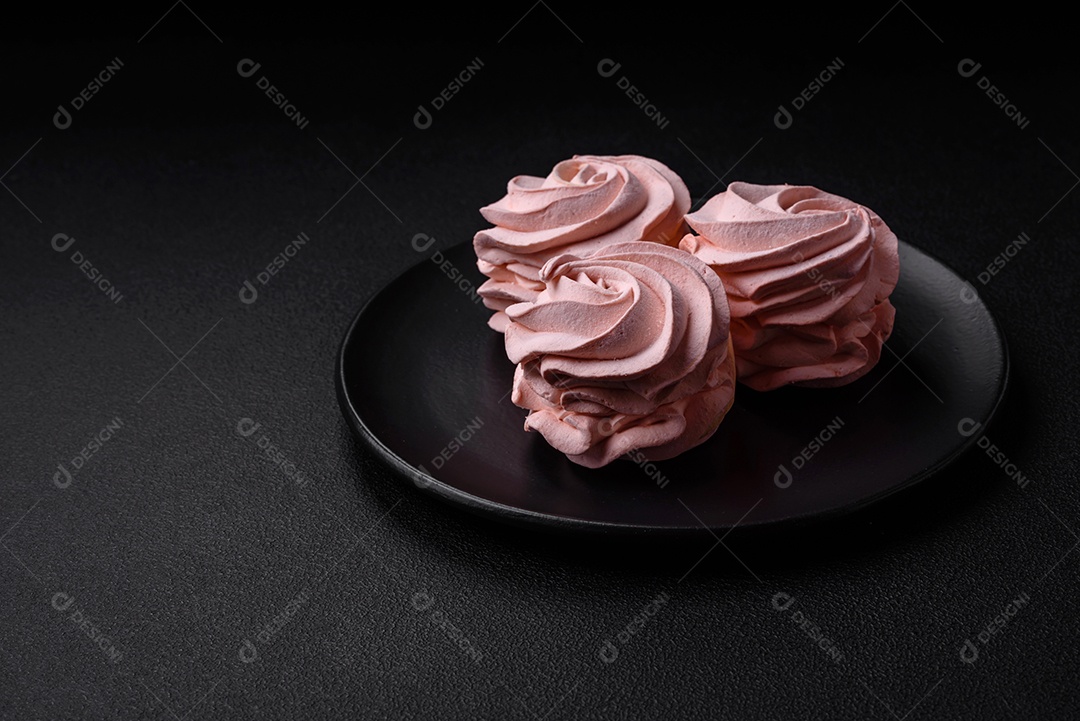 Delicioso marshmallow doce multicolorido em um fundo escuro de concreto. Doces saudáveis ​​para a mesa de jantar