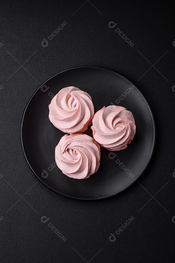 Delicioso marshmallow doce multicolorido em um fundo escuro de concreto. Doces saudáveis ​​para a mesa de jantar