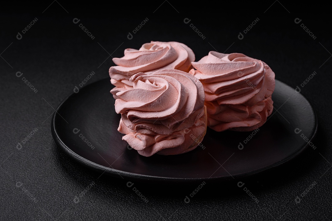 Delicioso marshmallow doce multicolorido em um fundo escuro de concreto. Doces saudáveis ​​para a mesa de jantar