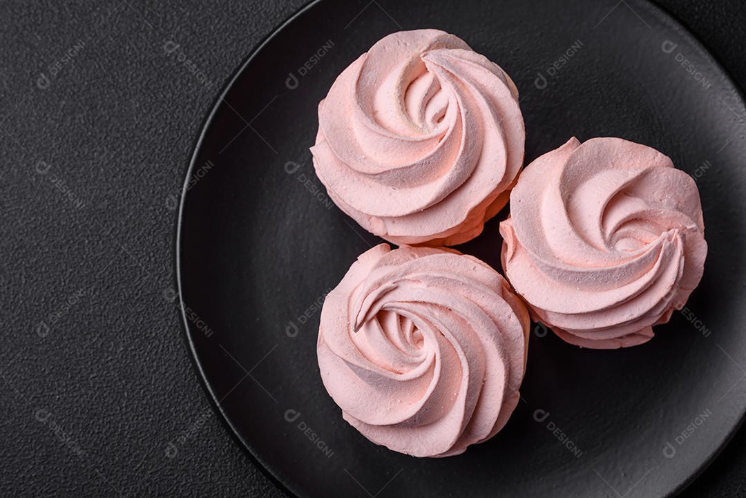 Delicioso marshmallow doce multicolorido em um fundo escuro de concreto. Doces saudáveis ​​para a mesa de jantar