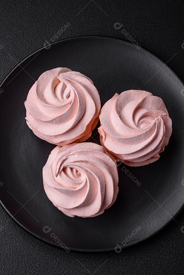 Delicioso marshmallow doce multicolorido em um fundo escuro de concreto. Doces saudáveis ​​para a mesa de jantar