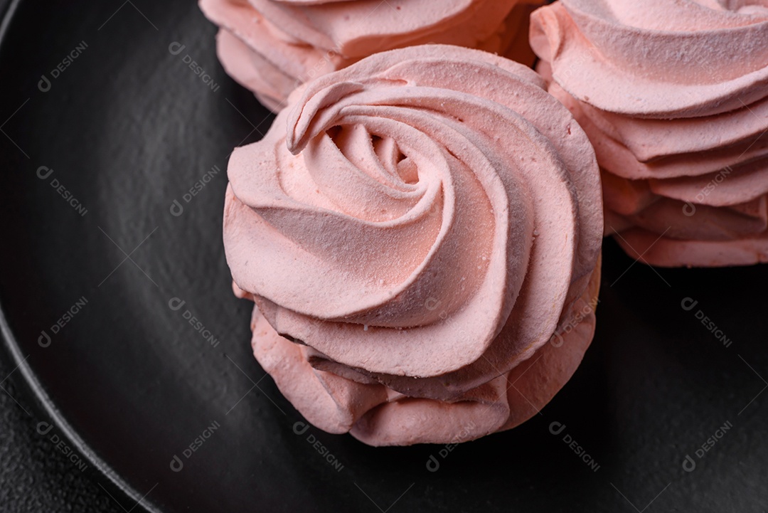 Delicioso marshmallow doce multicolorido em um fundo escuro de concreto. Doces saudáveis ​​para a mesa de jantar