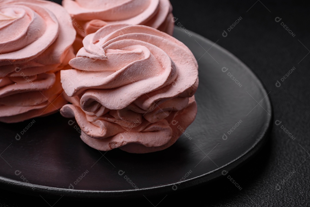 Delicioso marshmallow colorido doce em um fundo escuro de concreto. Doces saudáveis ​​para a mesa de jantar