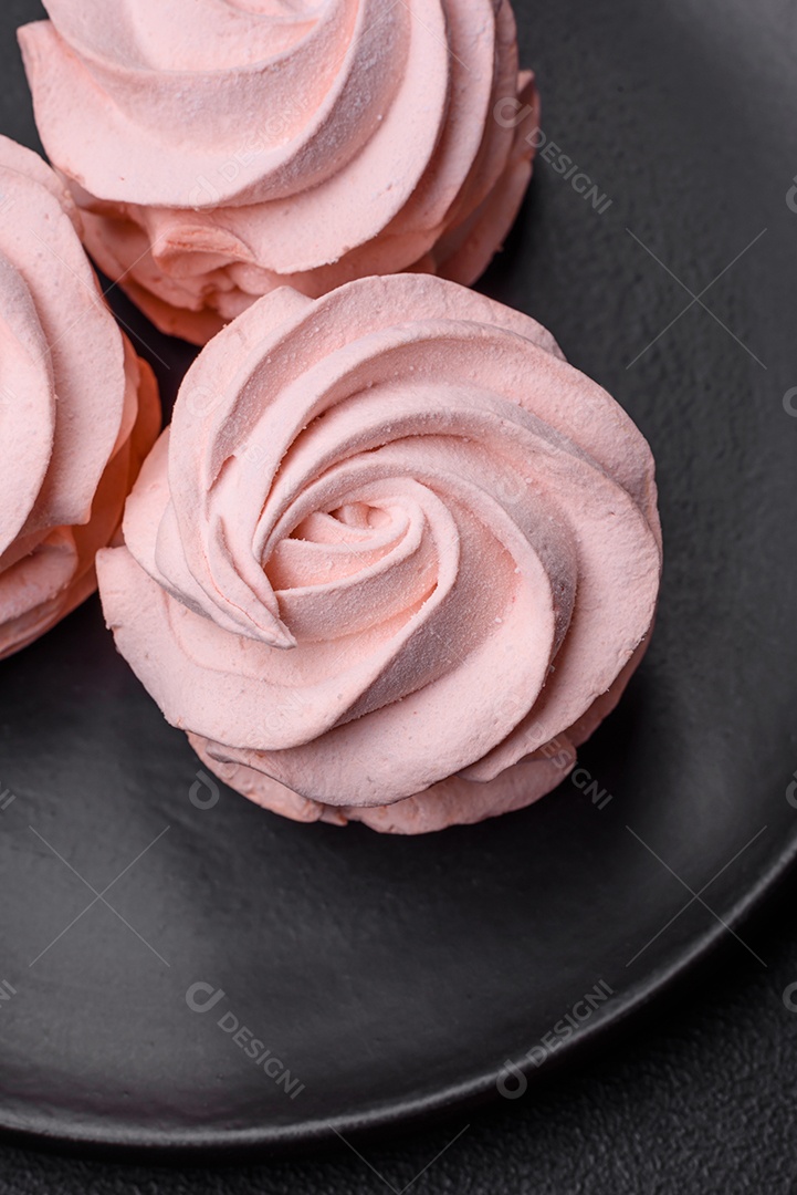 Delicioso marshmallow colorido doce em um fundo escuro de concreto. Doces saudáveis ​​para a mesa de jantar