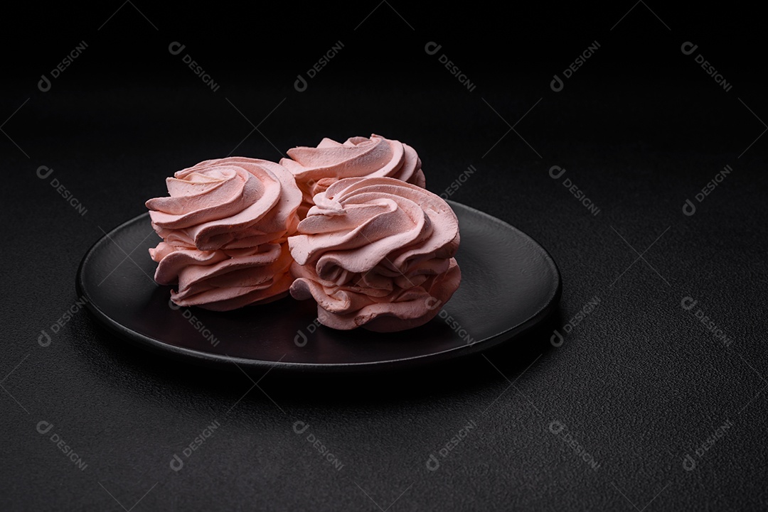 Delicioso marshmallow colorido doce em um fundo escuro de concreto. Doces saudáveis ​​para a mesa de jantar