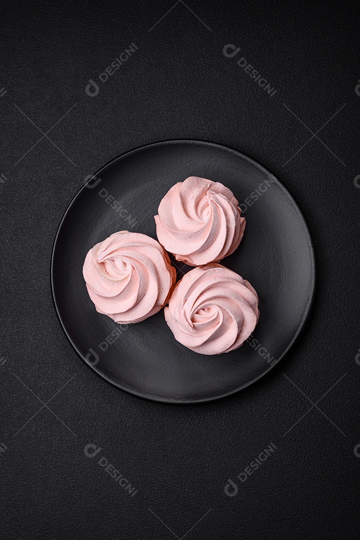 Delicioso marshmallow colorido doce em um fundo escuro de concreto. Doces saudáveis ​​para a mesa de jantar