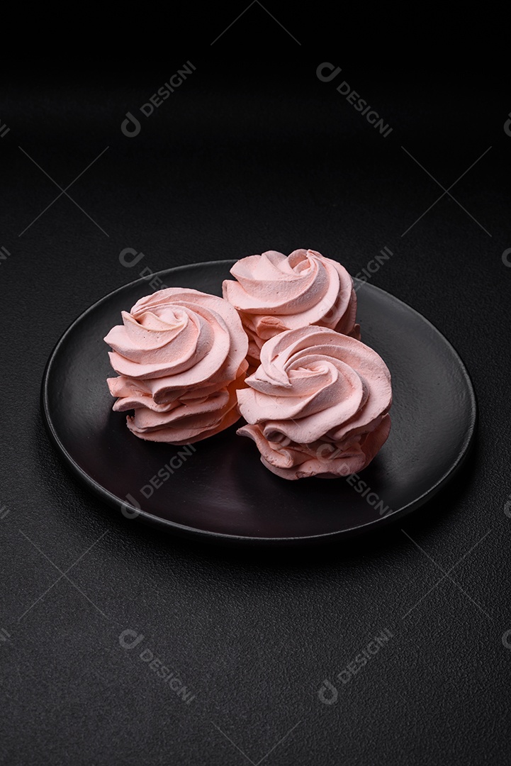 Delicioso marshmallow colorido doce em um fundo escuro de concreto. Doces saudáveis ​​para a mesa de jantar