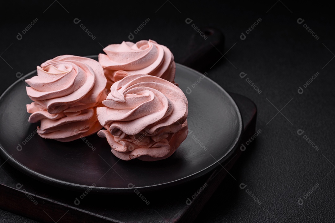 Delicioso marshmallow colorido doce em um fundo escuro de concreto. Doces saudáveis ​​para a mesa de jantar