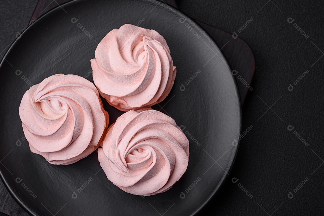 Delicioso marshmallow colorido doce em um fundo escuro de concreto. Doces saudáveis ​​para a mesa de jantar