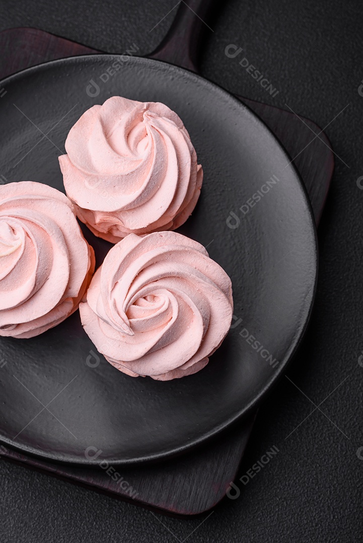 Delicioso marshmallow colorido doce em um fundo escuro de concreto. Doces saudáveis ​​para a mesa de jantar